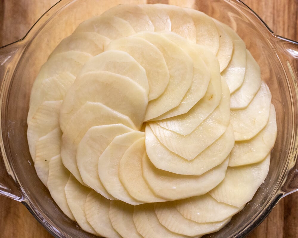 Potatoes and onions are layered and the dish is ready to go to oven