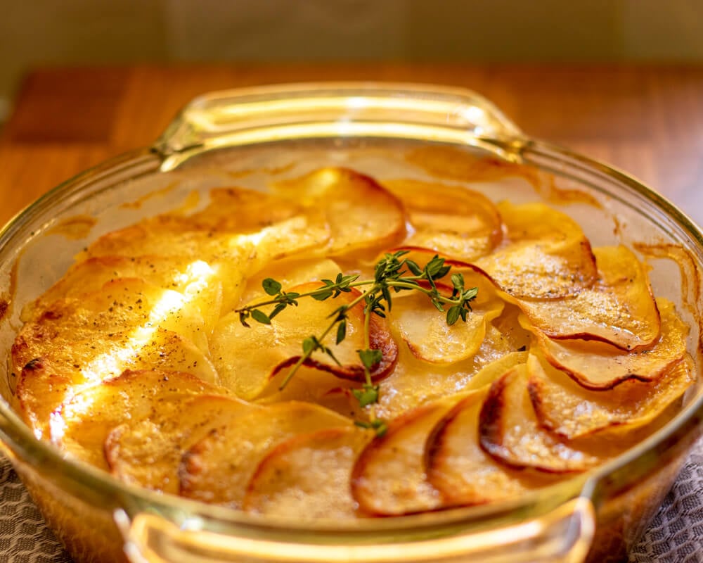 Potato Boulangere is baked until golden and garnished with few thyme sprigs