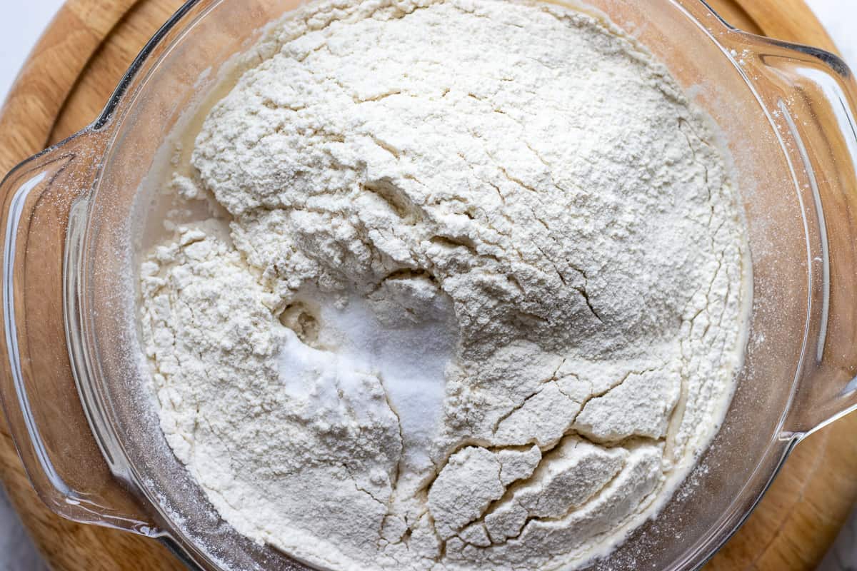 The flour and salt added to the bowl with yeast and water mixture