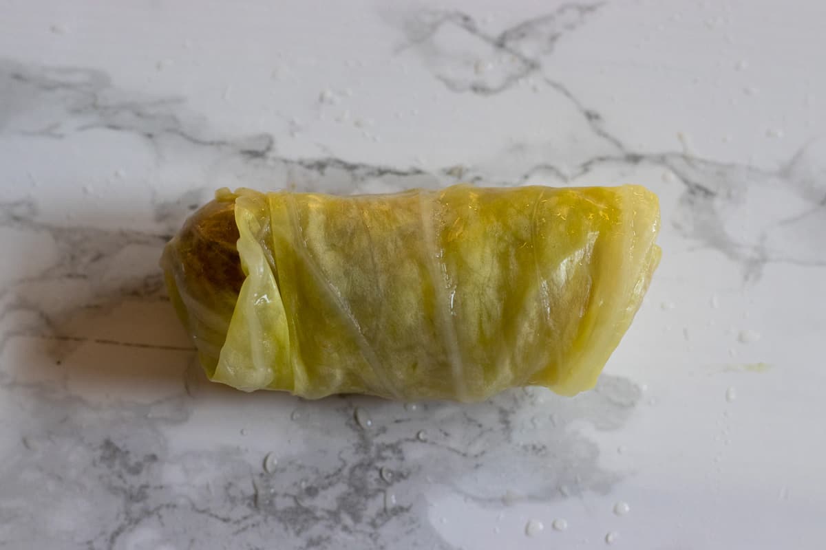 the rolled cabbage leaf is gently squeezed to secure it