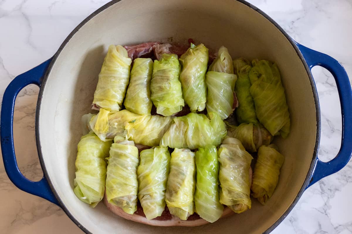 the stuffed cabbage leaves are arranged on the bottom of the pan