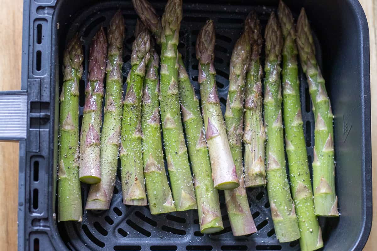 asparagus spears are covered with oil and seasoning