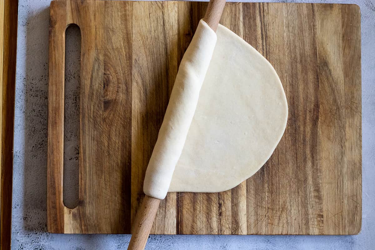 rolling out a dough ball using a thin rolling pin