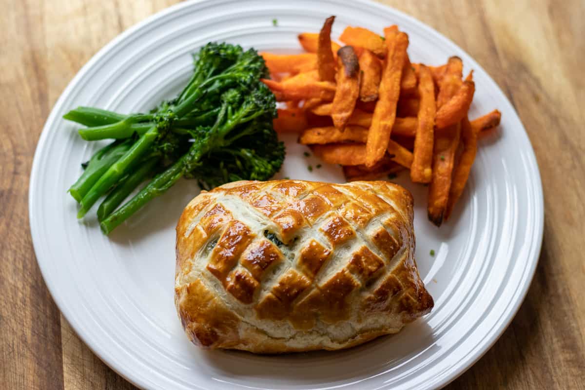 salmon wellington served with sweet potato fries and green vegetables 