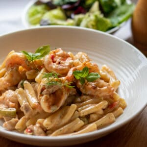 creamy Cajun Chicken and prawn pasta served with a bowl of pasta