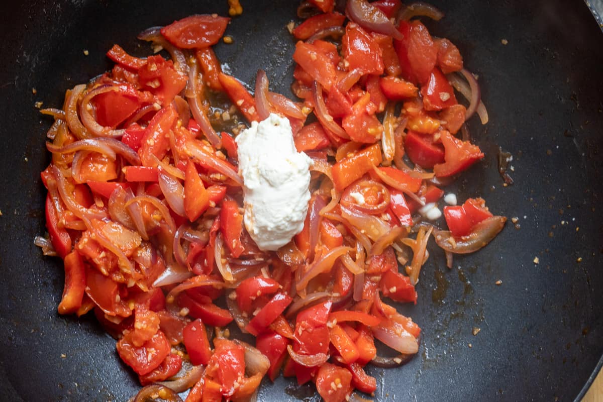 mascarpone cheese is added to the tomatoes and peppers