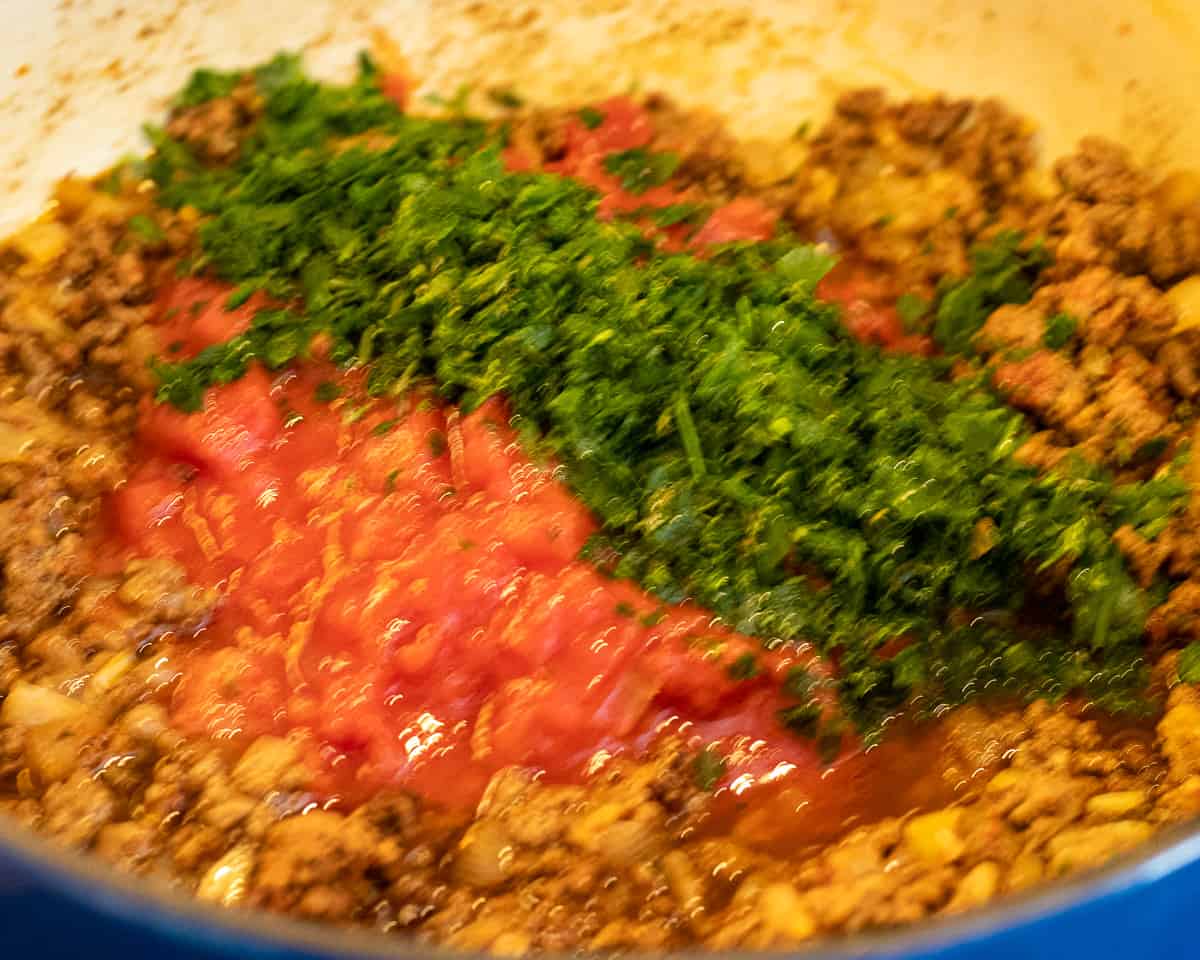 Tomatoes, parsley and stock goes to the meat sauce.