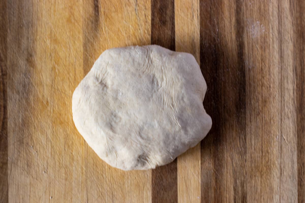 The sides of the dough are sealed to form a ball