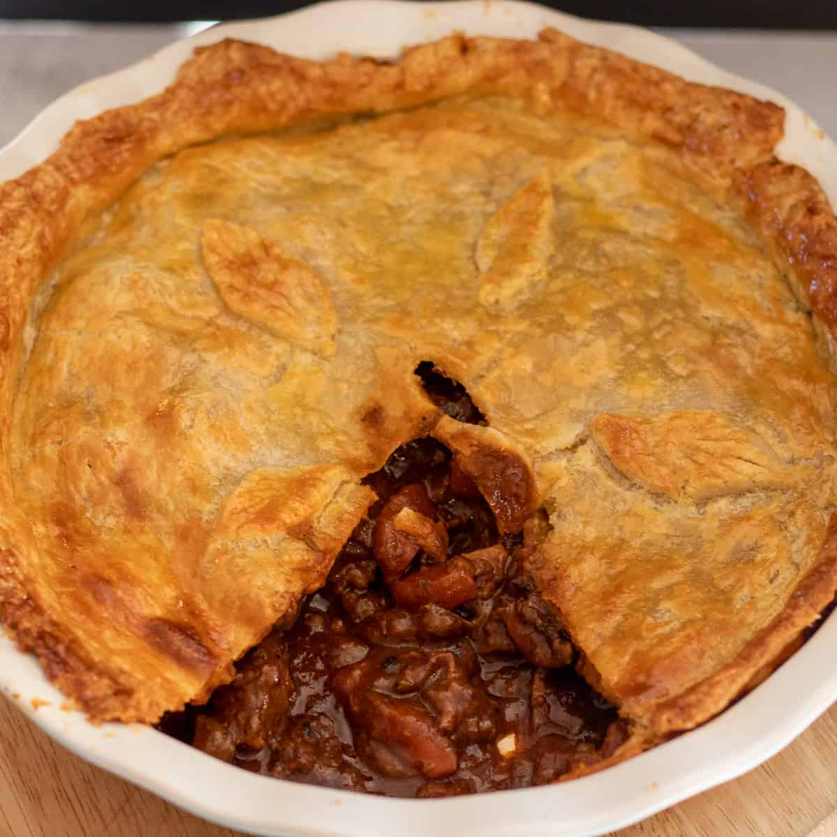 a portion of steak pie is removed from the pie dish