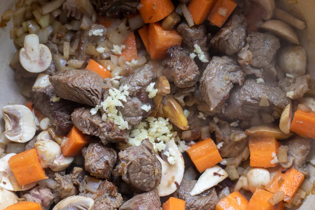 carrots, garlic and mushrooms are added to the beef