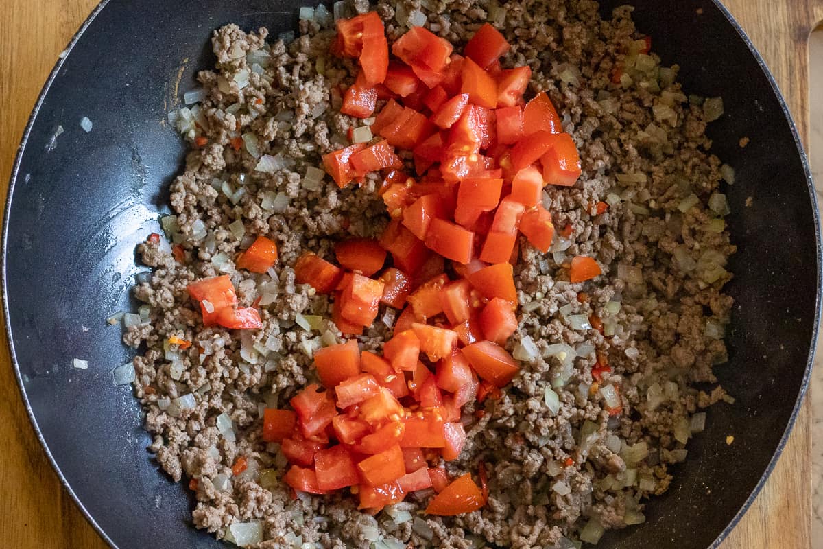 diced tomatoes are added to the ground beef mixture