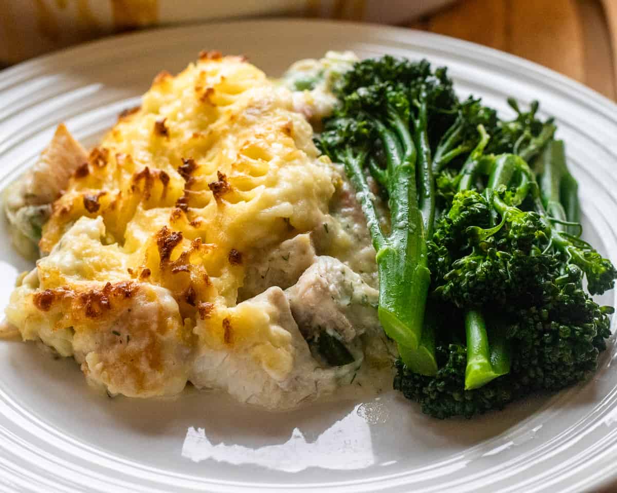 fish pie with cheesy mashed potato topping served with broccoli sprouts