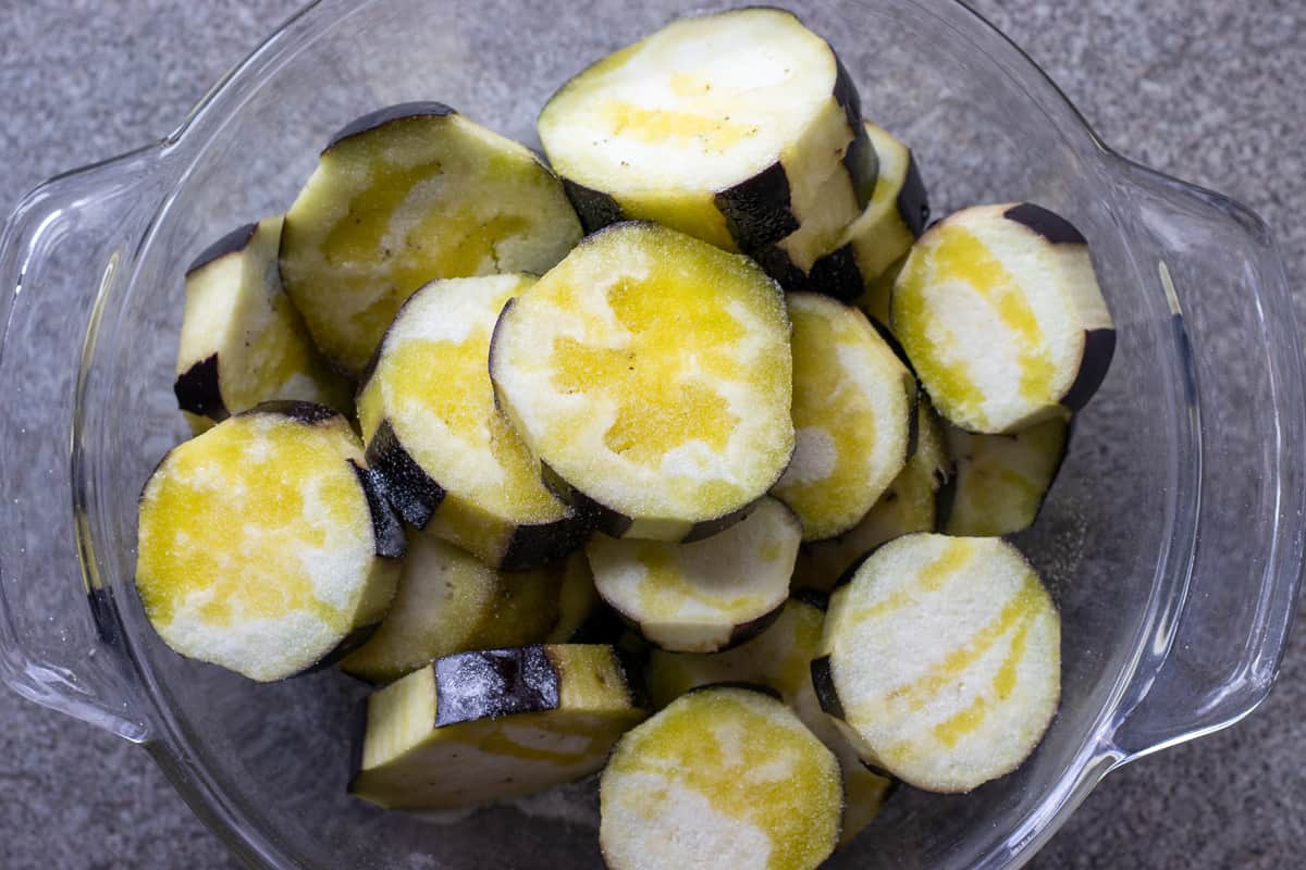 sliced aubergines are drizzled with olive oil