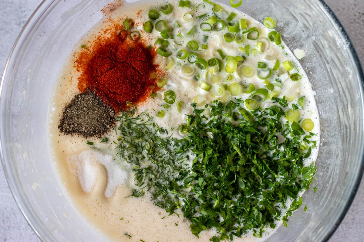 herbs, cheese, seasoning and spring onions are added to the mixture