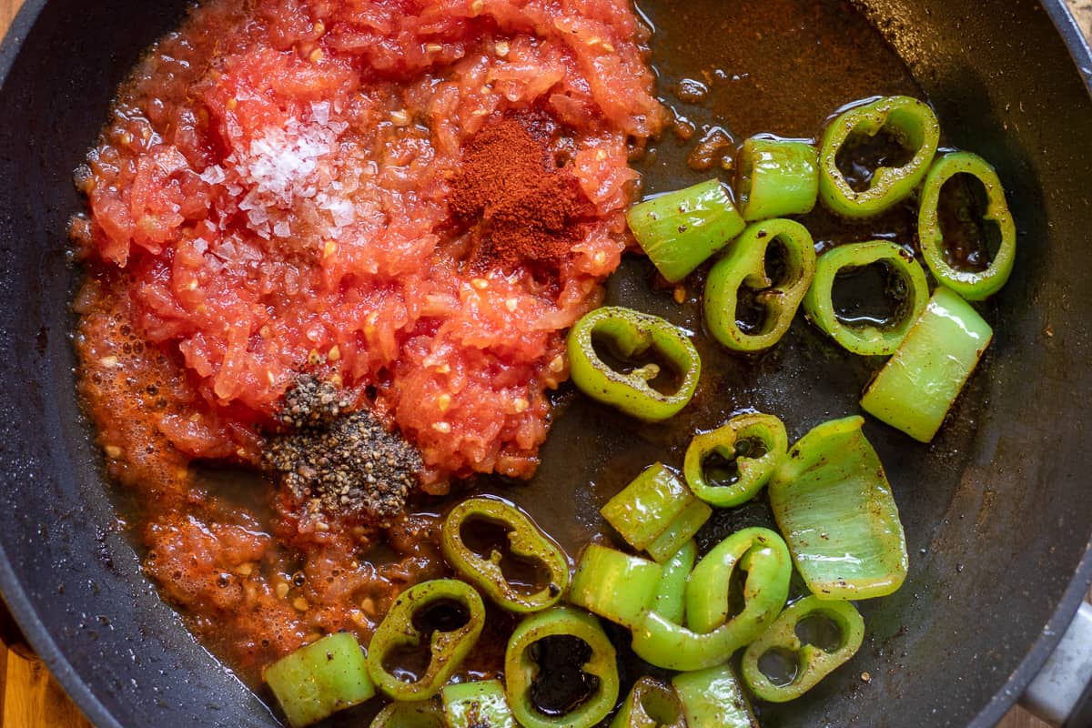 the tomatoes and seasoning are added to the peppers