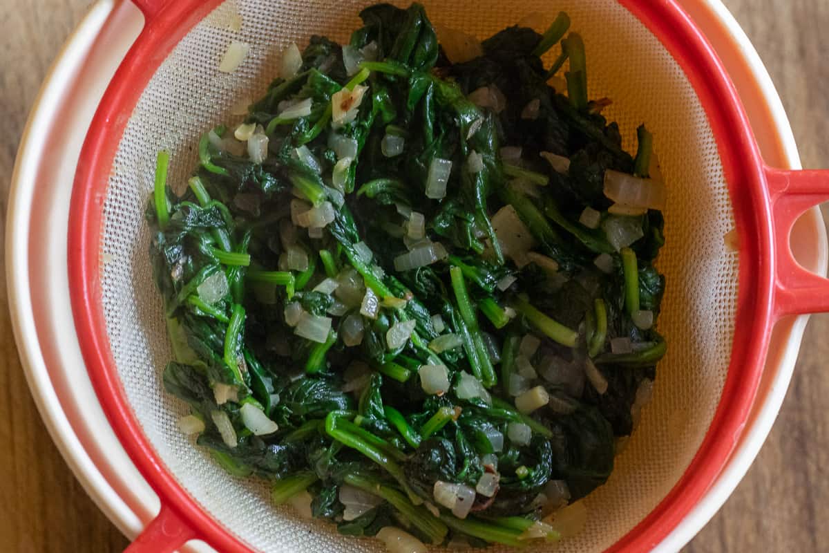 Spinach and onions are on a sieve