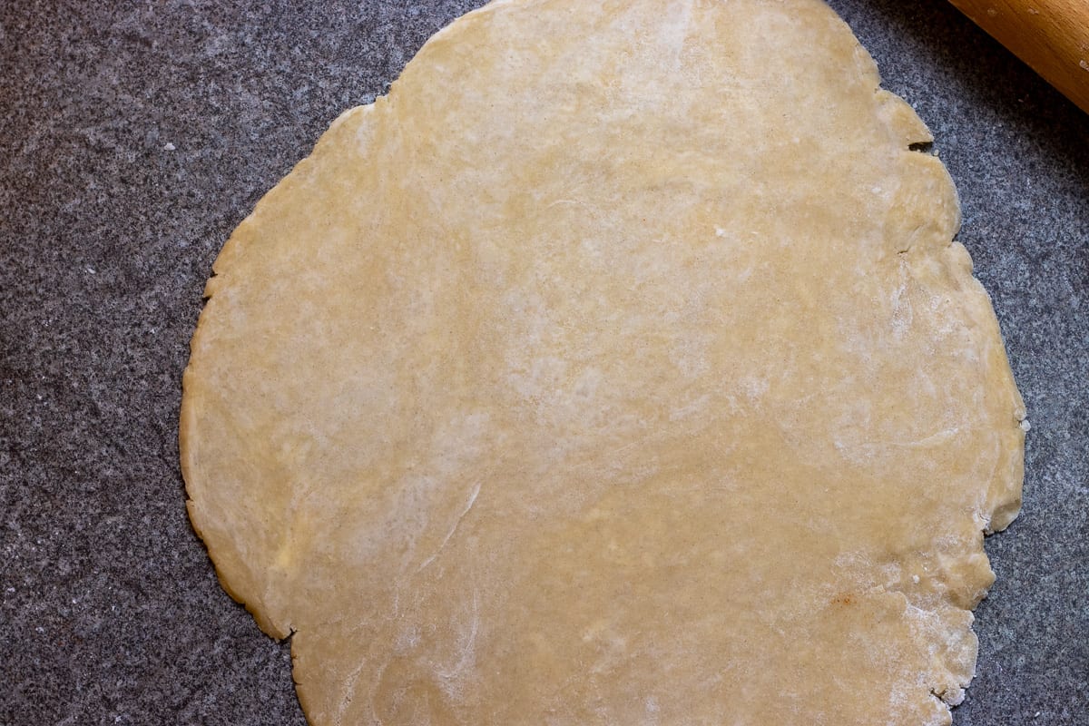 quiche dough is rolled out into a circle