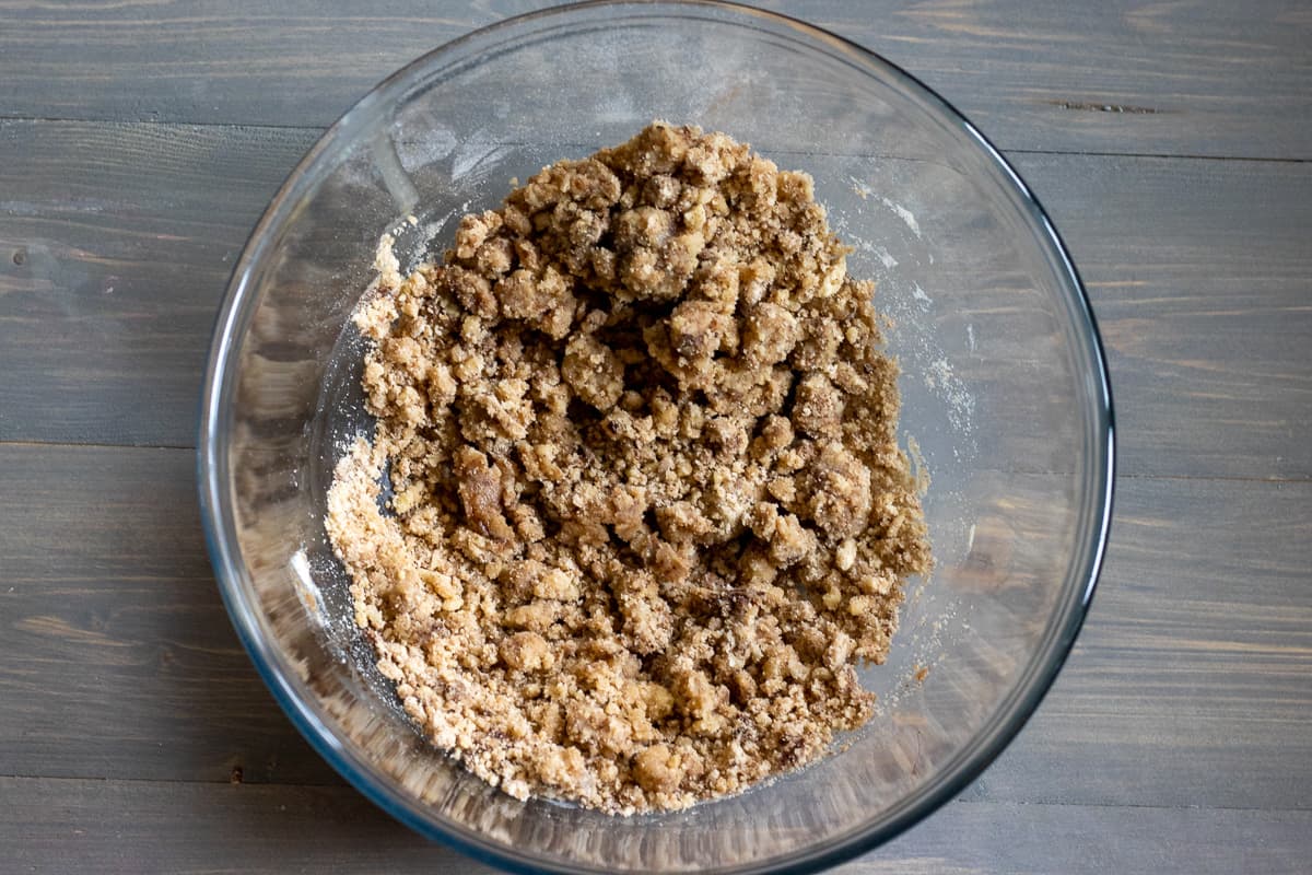 butter, sugar, cinnamon and flour are mixed in a bowl to form a crumble