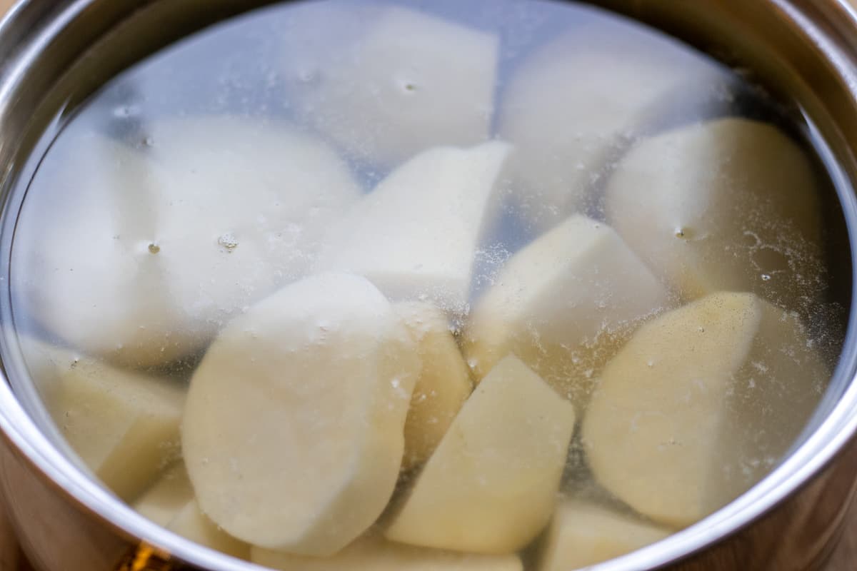 The potatoes are peeled, cut and placed in a pan filled with cold water