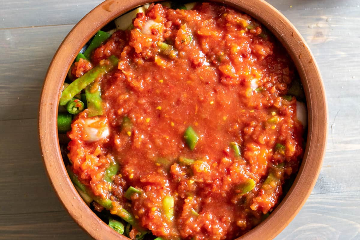 tomato sauce is poured over the vegetables