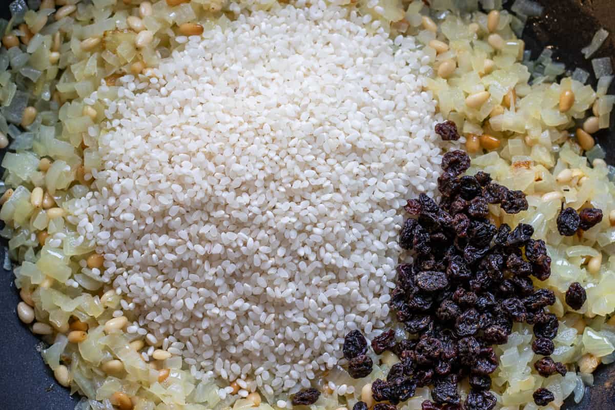 the rice and currants are added to onions and pine nuts