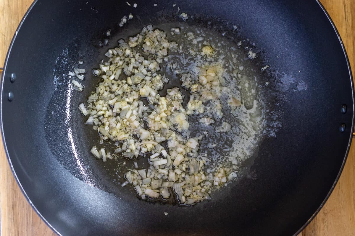Gently cooking the shallots and garlic with butter in a pan