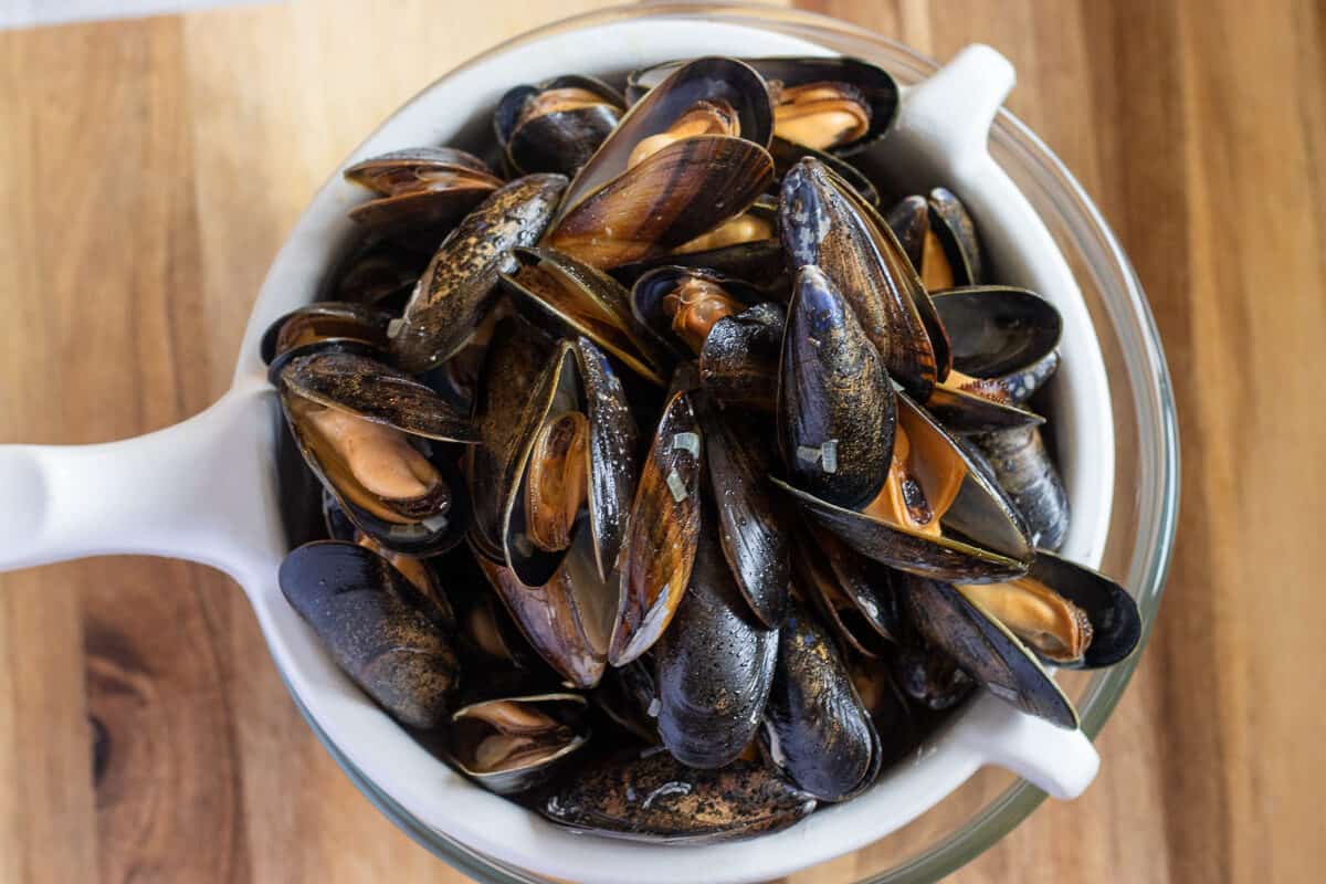 cooked mussels are placed on a sieve