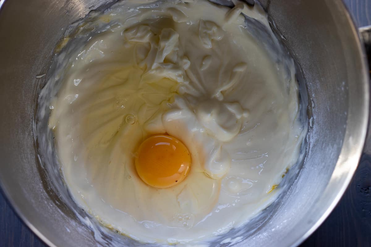 adding the eggs one at a time to cream cheese mixture