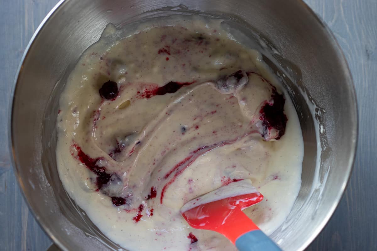 cranberry sauce is stirred in the cream cheese mixture