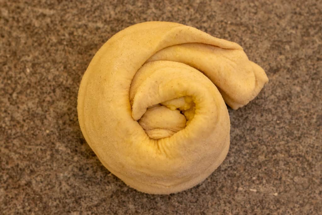 the pleated dough is coiled into a spiral shape