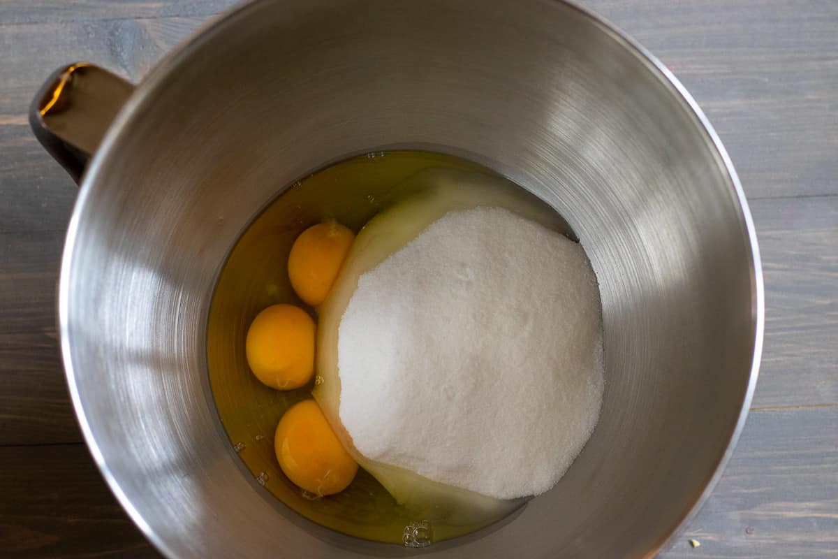 eggs and sugar are placed in a bowl of a stand mixer