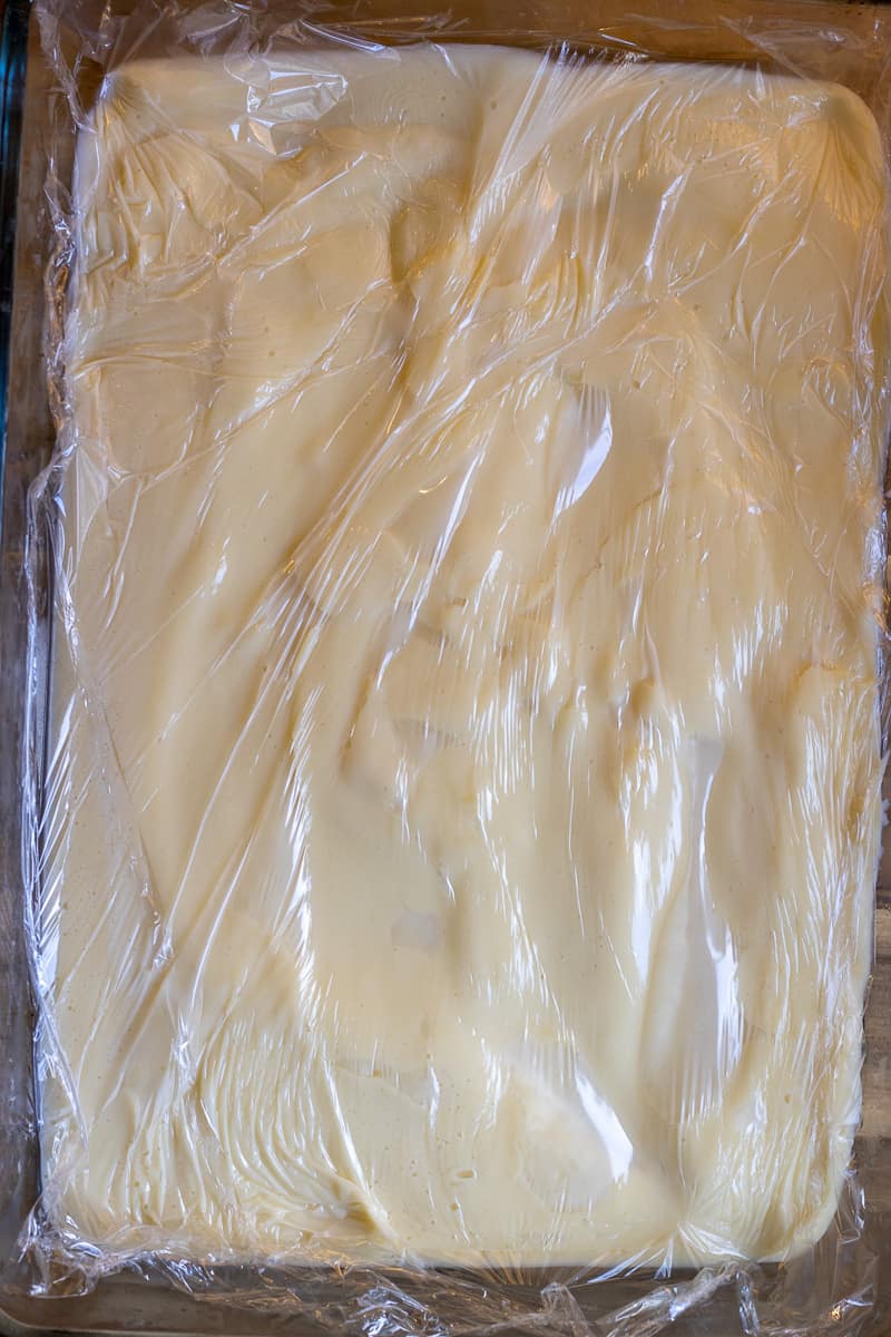 pastry cream is spread on a baking sheet for cooling