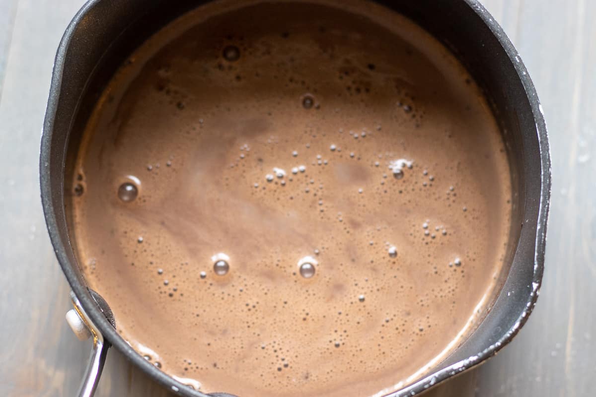 Water, cacao powder, salt and sugar is placed in a pan for making chocolate sauce