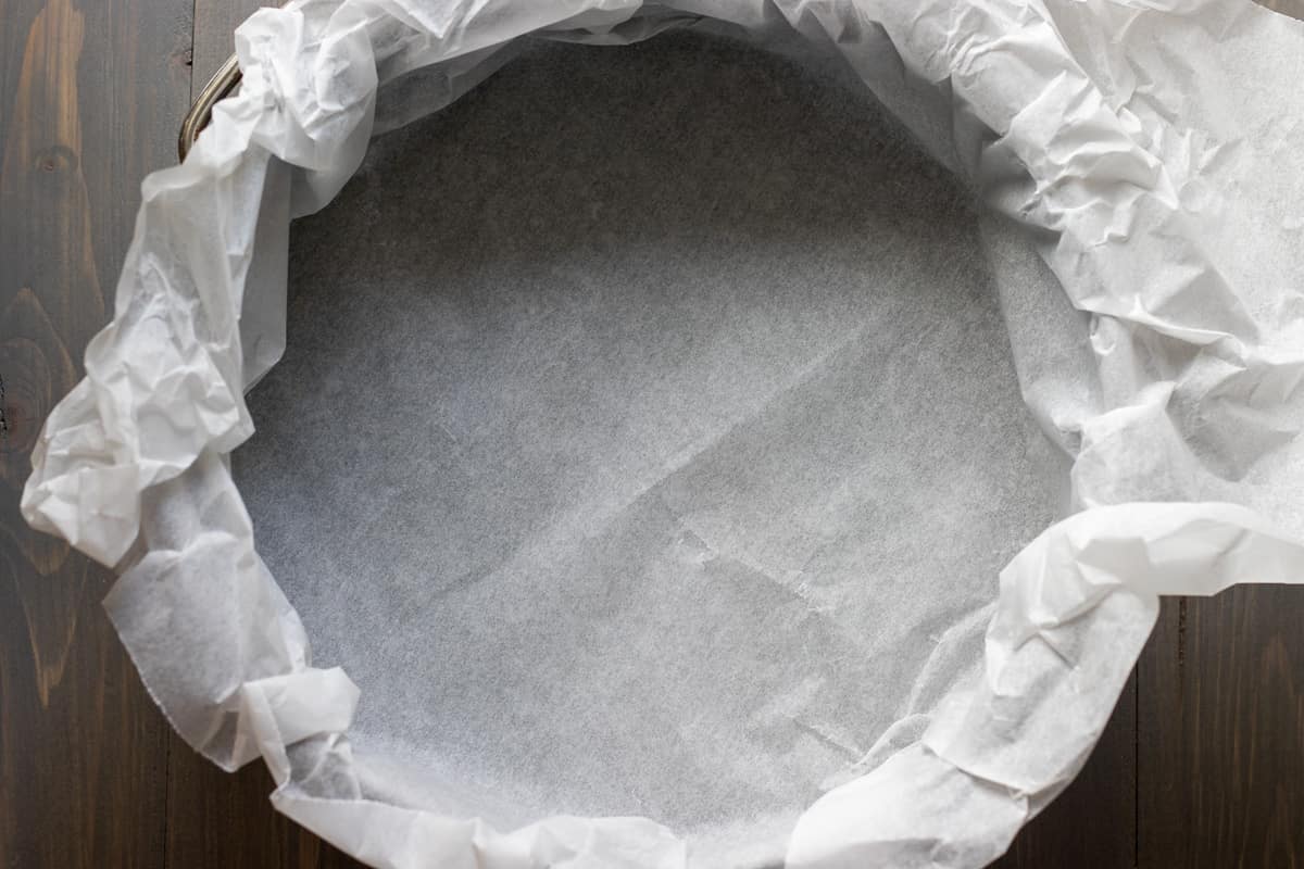 Springform cake tin is lined with parchment paper