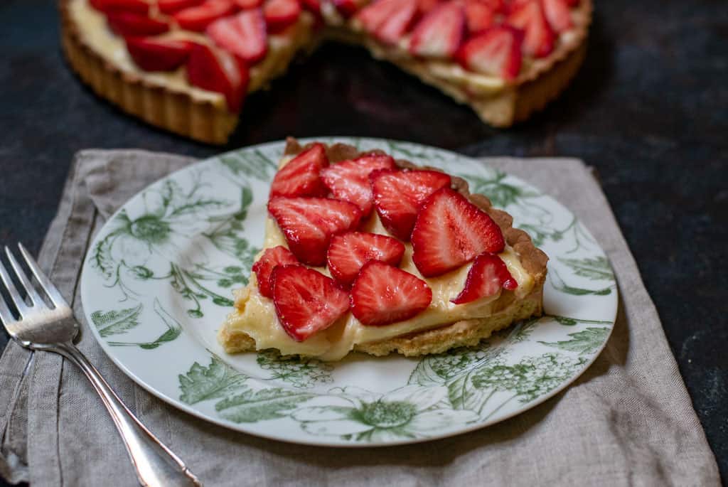 A slice of Tart aux Fraises - French Strawberry Tart with Custard served on a plate