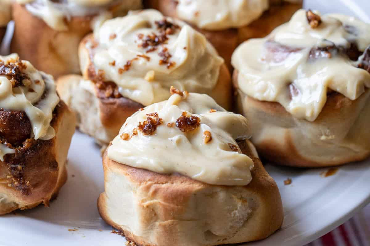 cinnamon rolls are baked in an air fryer and slathered with cream cheese frosting 