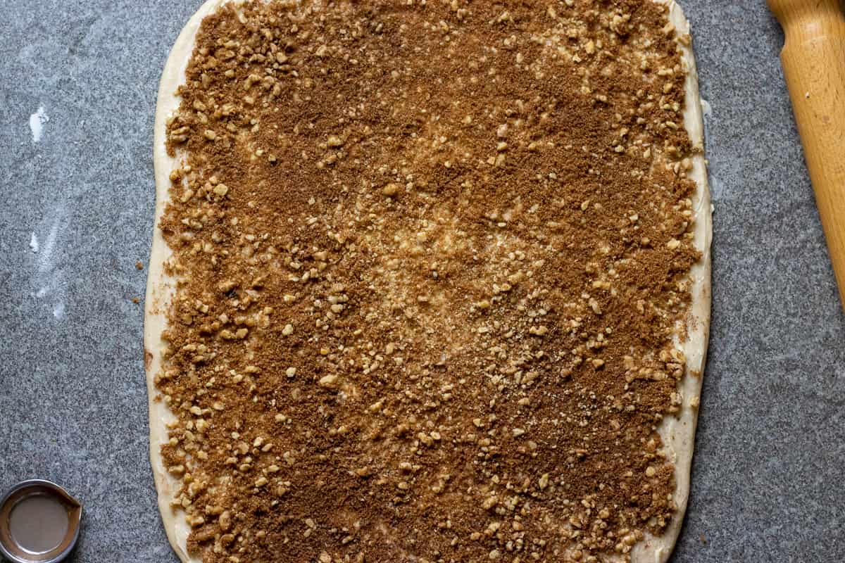 cinnamon, sugar and walnuts are Sprinkled over the dough