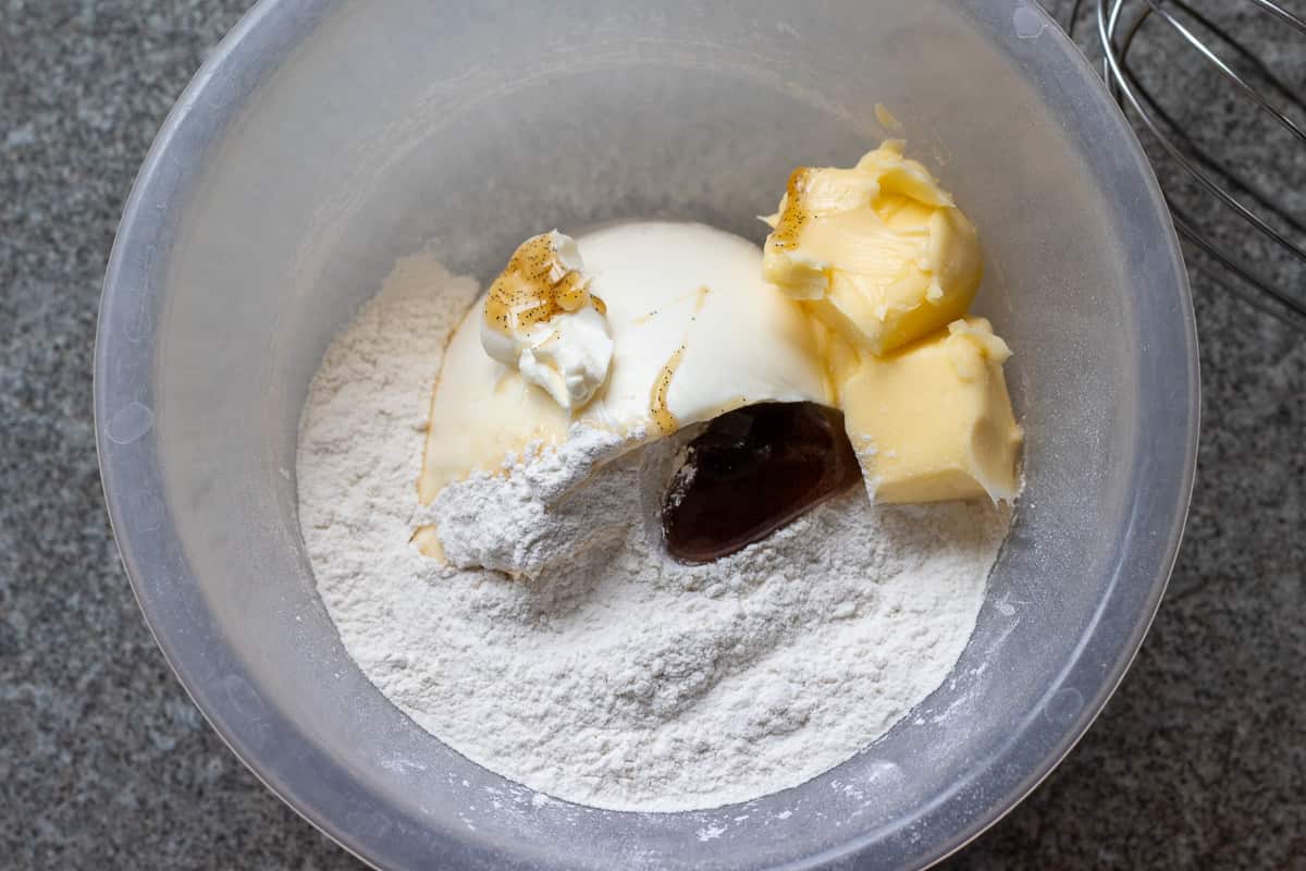 cream cheese , butter, icing sugar and vanilla are placed in a bowl 