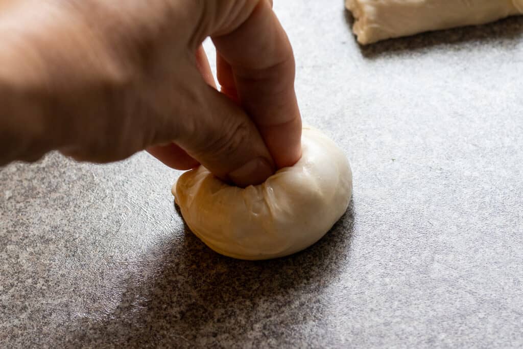 shaping a piece of dough into a ball