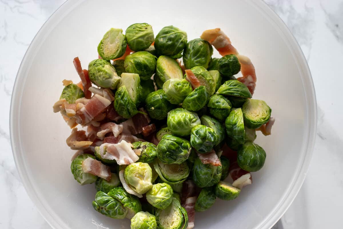 place the bacon, brussel sprouts, olive oil and seasoning in a bowl