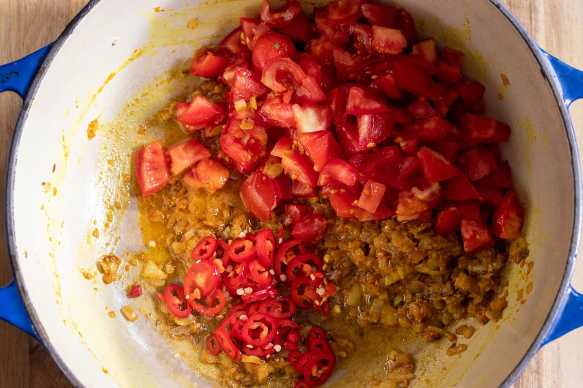 chopped tomatoes and chilies are added to the pan