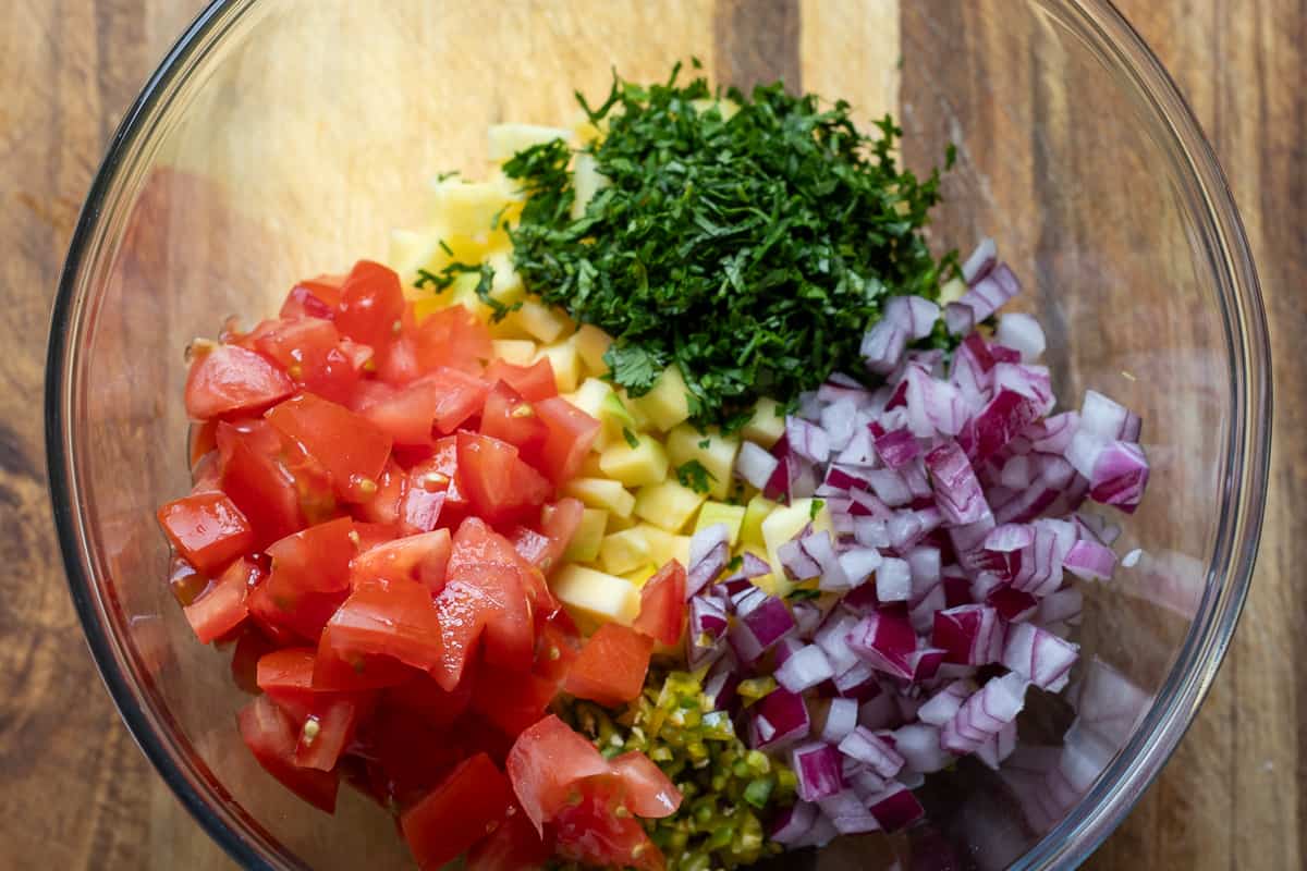 chopped ingredients for mango pico de Gallo are placed in a bowl 