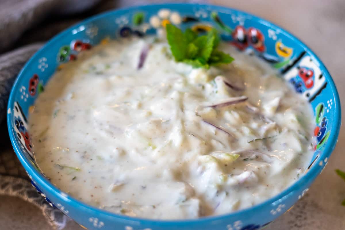 Onion raita is garnished with a mint tip