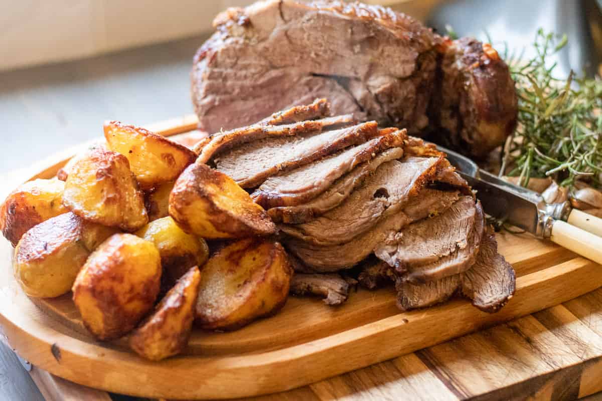 sliced boneless leg of lamb is served with roasted potatoes