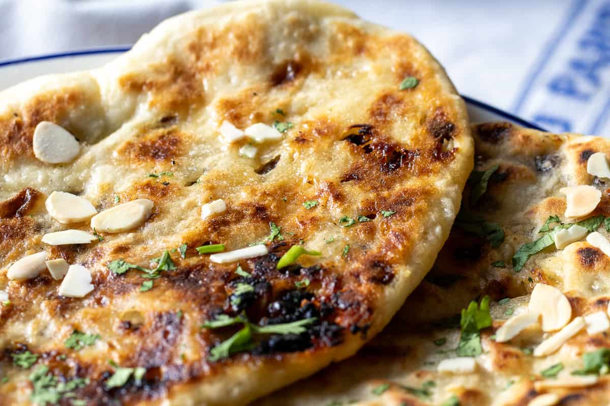 freshly cooked peshwari naan is garnished with coriander and almonds
