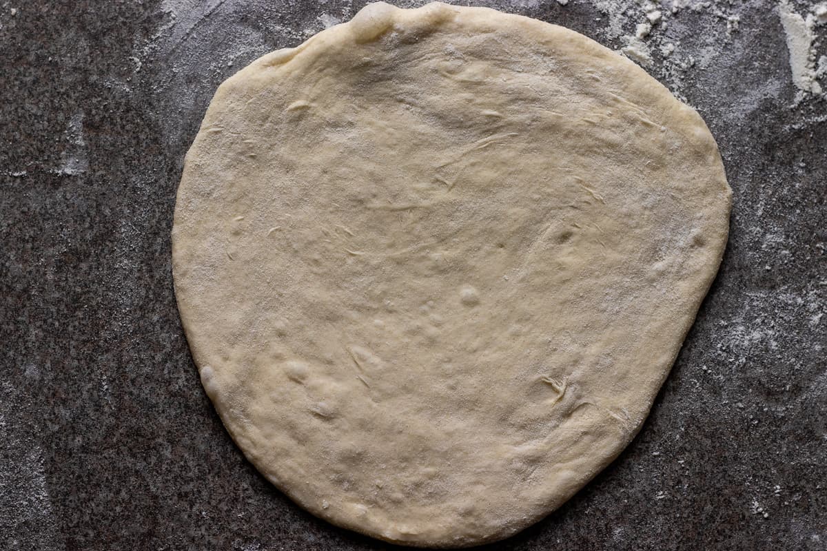 a dough ball is rolled out into a small circle