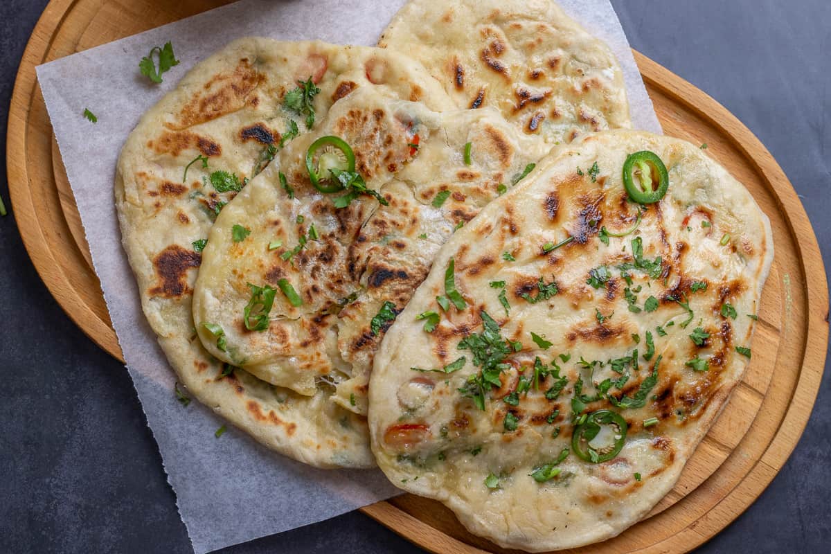 4 pieces of bullet naan on a wooden board
