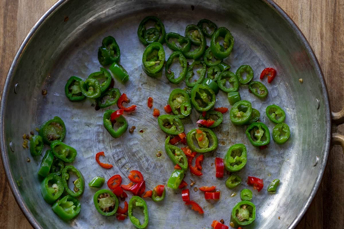 Sautéing the peppers in a copper pan with olive oil
