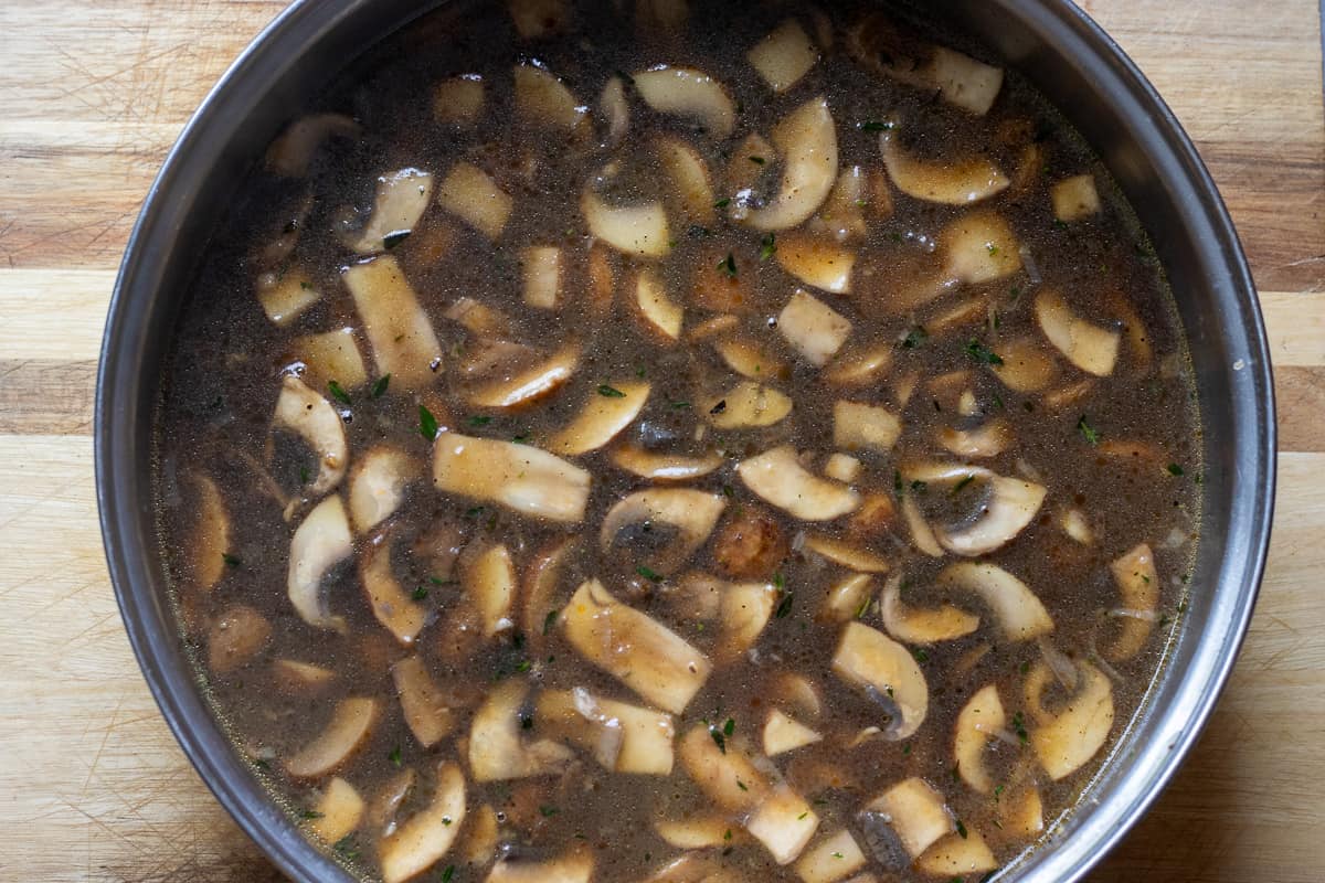 beef stock is added to mushrooms