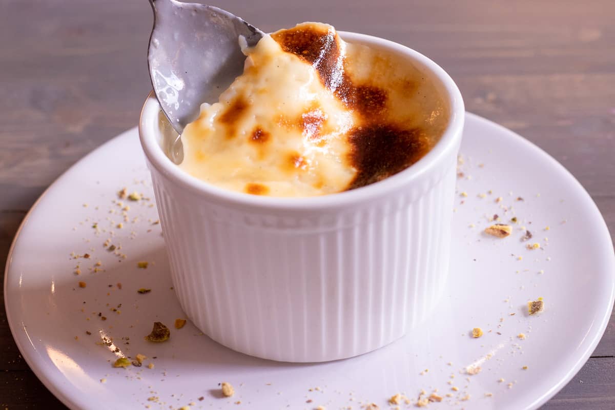 taking a spoonful of baked Turkish rice pudding 